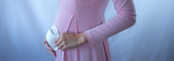 Kobieta w ciąży z maseczką na brzuchu