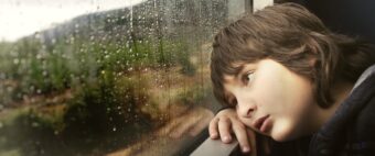 Smutny chłopiec przy oknie