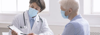 Lekarz rozmawia z pacjentem - oboje w maseczkach
